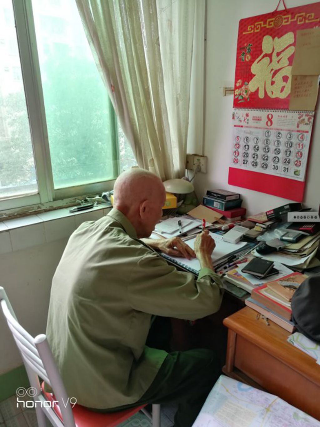 1574218000248706.jpg 老党员张增补平日里喜欢读书写字.jpg